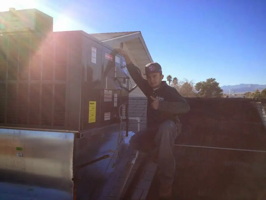 HVAC technician performing Heat Pump Repair on a rooftop unit in Holly Ridge